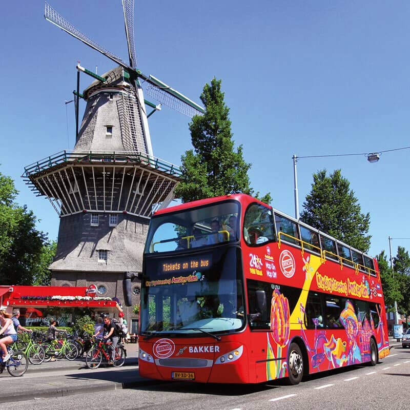 City Sightseeing Hop-on Hop-off by bus in Amsterdam passing a windmill